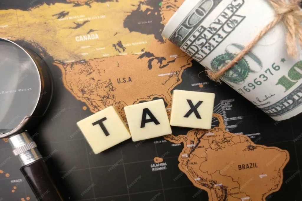Magnifying glass and banknotes with the word TAX on a world map background