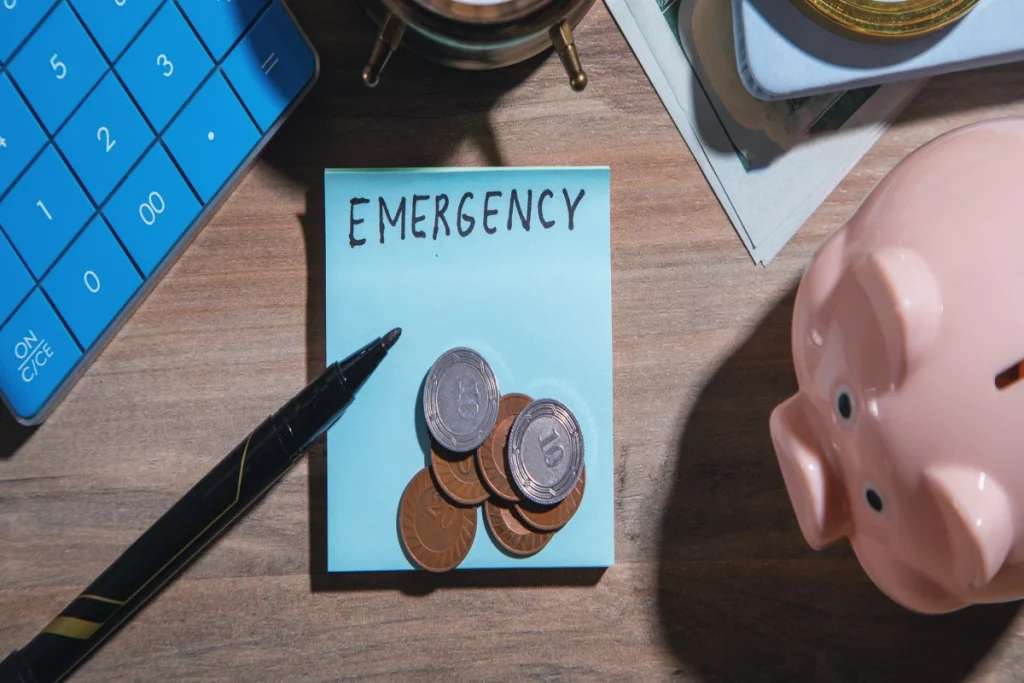 word emergency with coins and a piggy bank